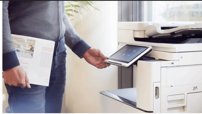 man in an office using a touchscreen printer